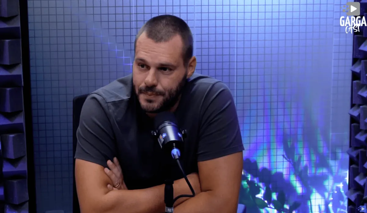 Convidado ao microfone no cenário de LED azul, durante transmissão do Gargacast